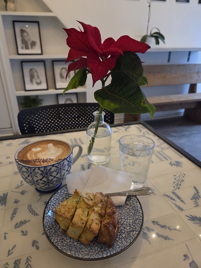 Beautifully crafted latte with cake on patterned table at Moments