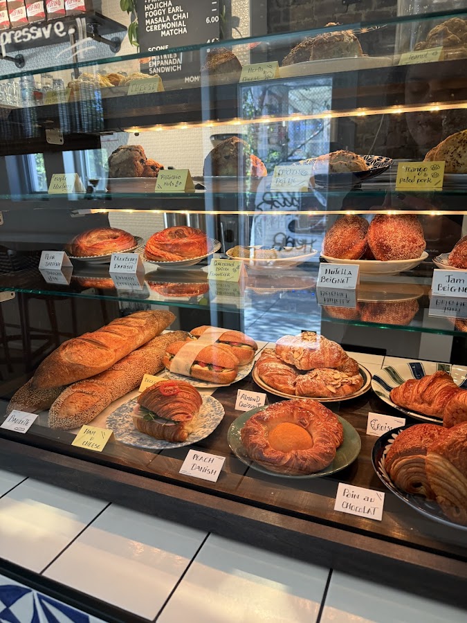 Fresh baked goods display case at Moments with labeled pastries