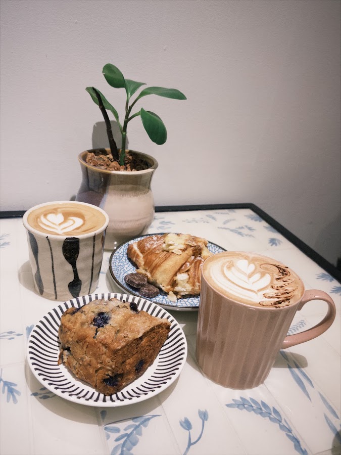 Lattes and pastries on patterned cafe table